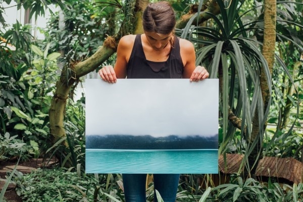 woman outside holding up blank canvas