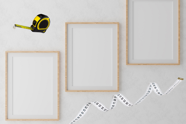 frames on a wall with measuring tape