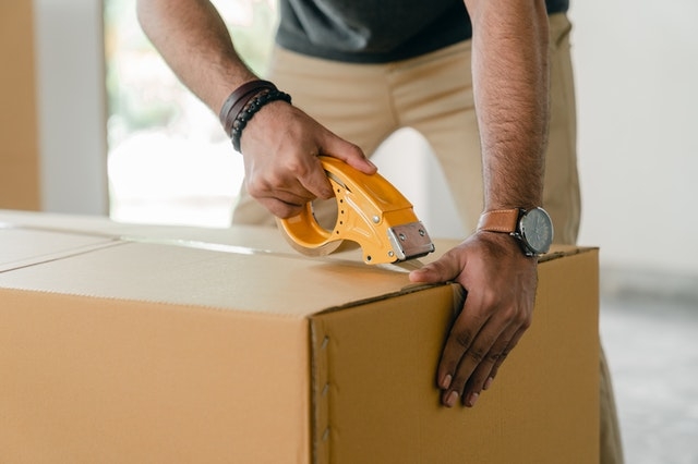 man tape a box for storage