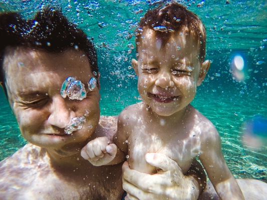 photo of father and son under water